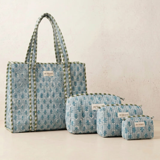 Set of blue patterned bags with visible brand name on a light background