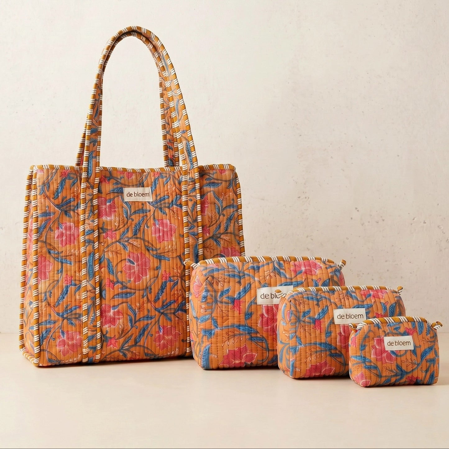 Set of floral-patterned bags with 'de Bloem' branding on a light background