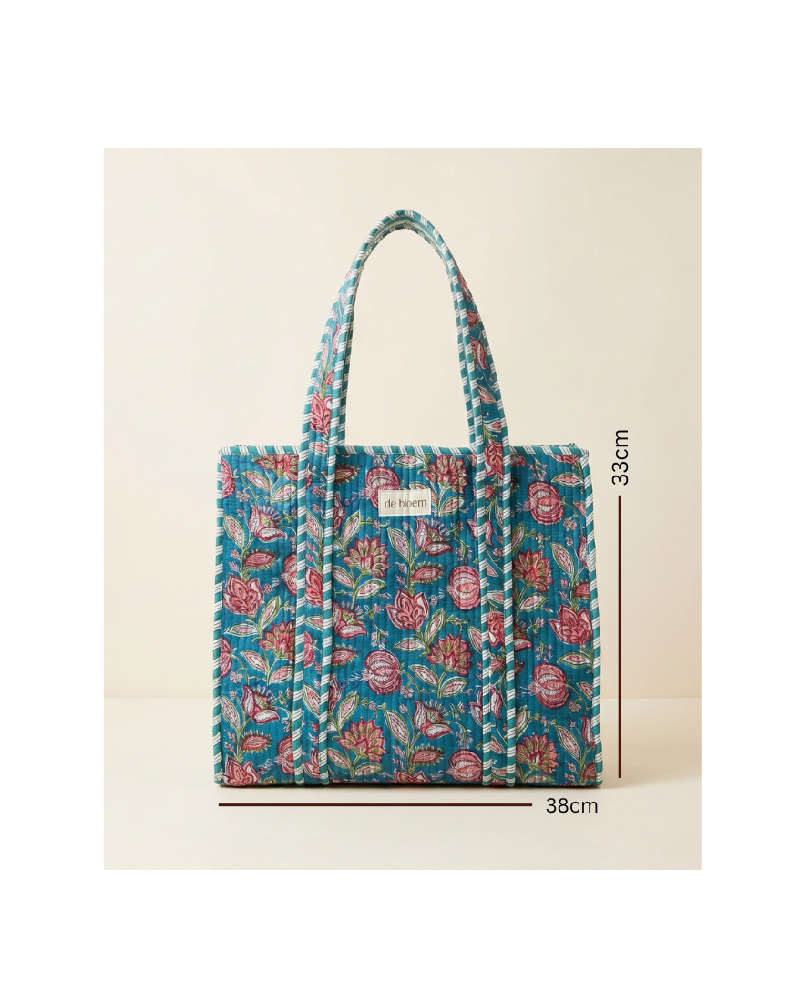 A tote bag with a blue floral and leaf pattern, featuring thick braided shoulder straps, shown with black dimension lines and text indicating measurements of 38cm width and 33cm height on a light beige background.