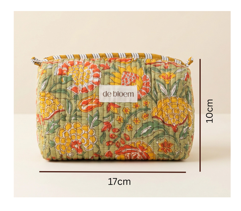 A quilted cosmetic pouch with a colorful floral and pineapple pattern, shown with dimension lines indicating a height of 10cm and a width of 17cm. The brand label 'de bloem' is visible on the front.