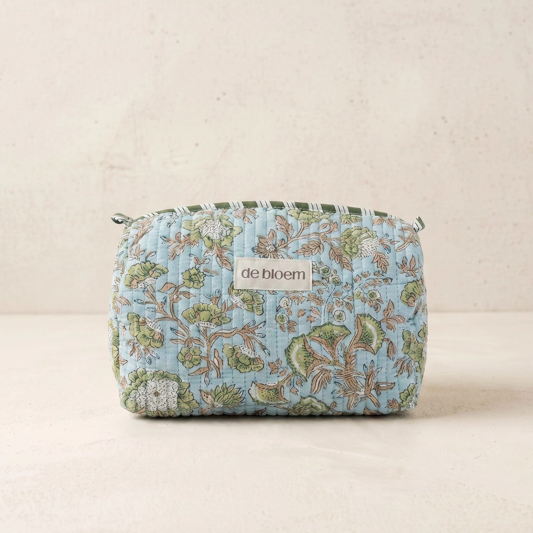 Floral patterned pouch with 'de bloem' branding on a beige background