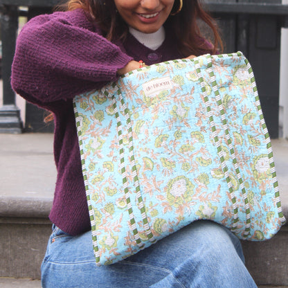 Woman holding a floral-patterned bag outdoors