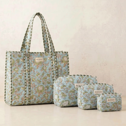 Set of floral-patterned bags including a tote, pouches, and small bag on a beige background.