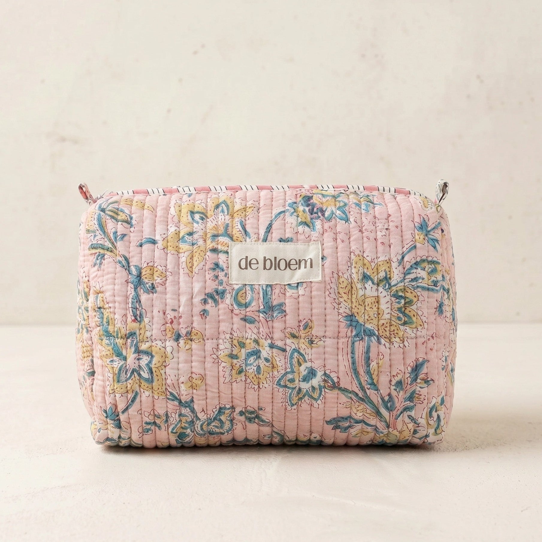 Floral patterned pouch with 'de bloem' label on a light background