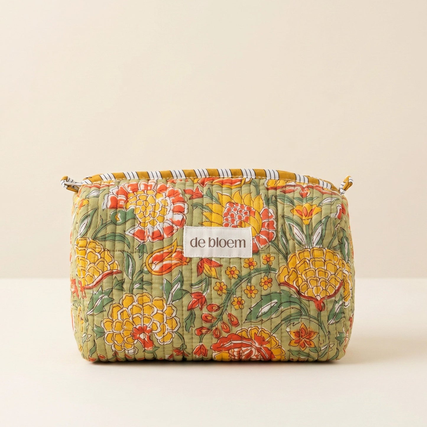 Floral-patterned pouch with 'de bloem' label on a beige background
