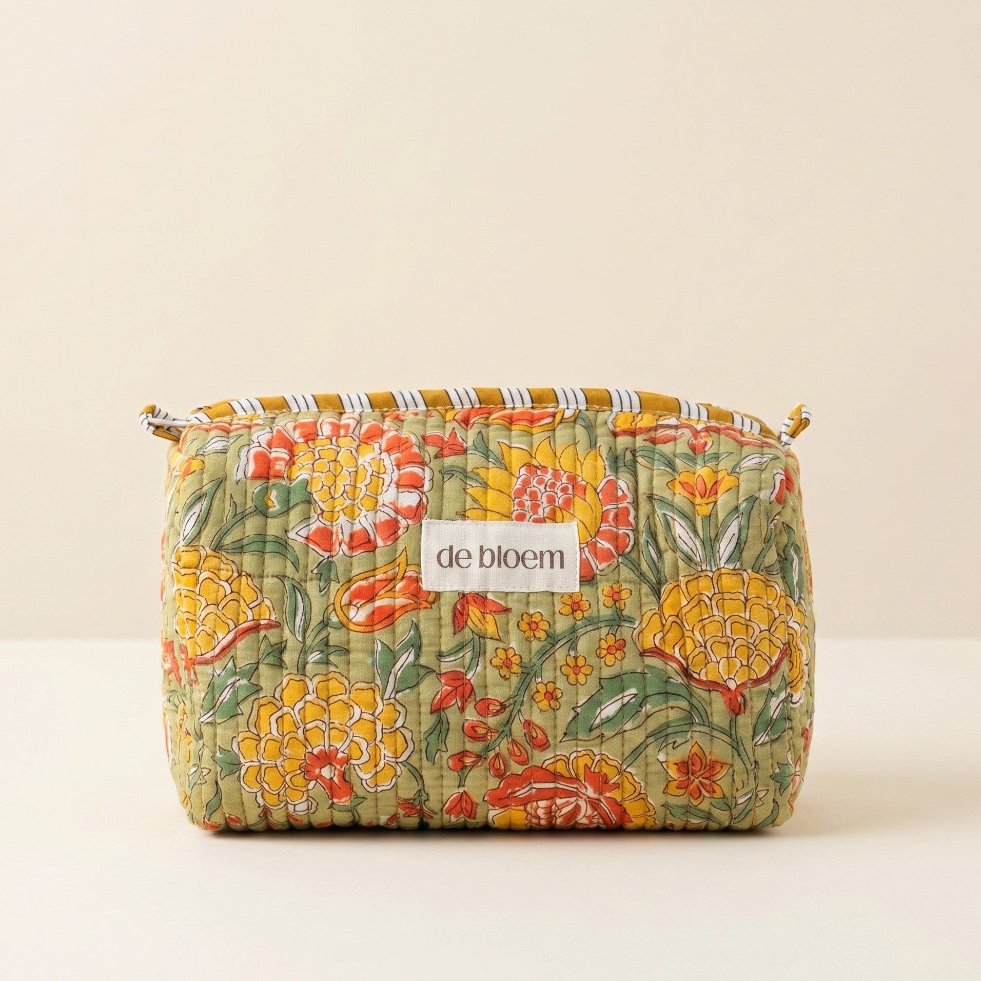 Floral-patterned pouch with 'de bloem' label on a beige background