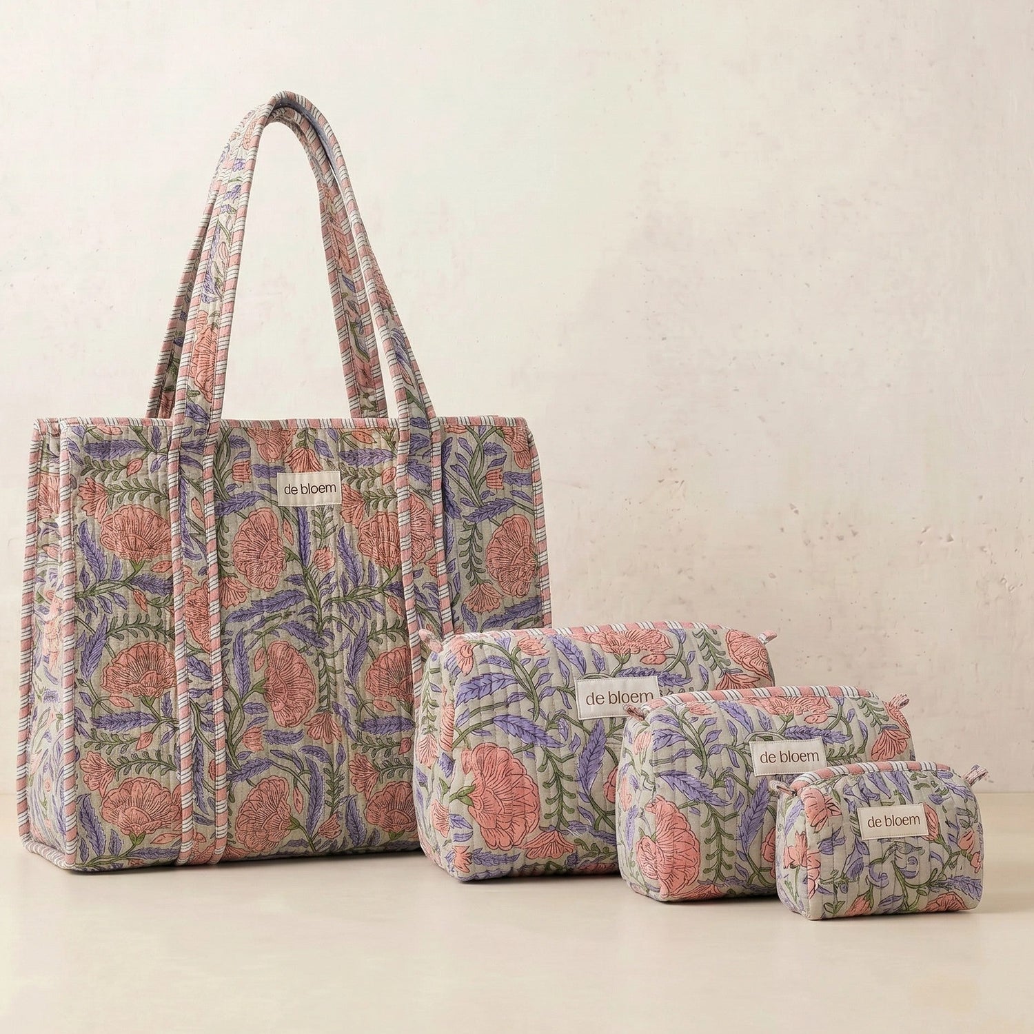 Set of floral-patterned bags including a tote and three pouches on a light background