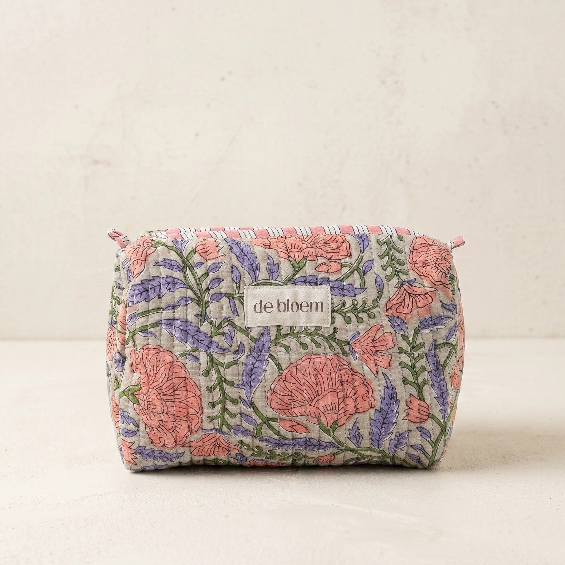 Floral-patterned pouch with 'de bloem' branding on a beige background