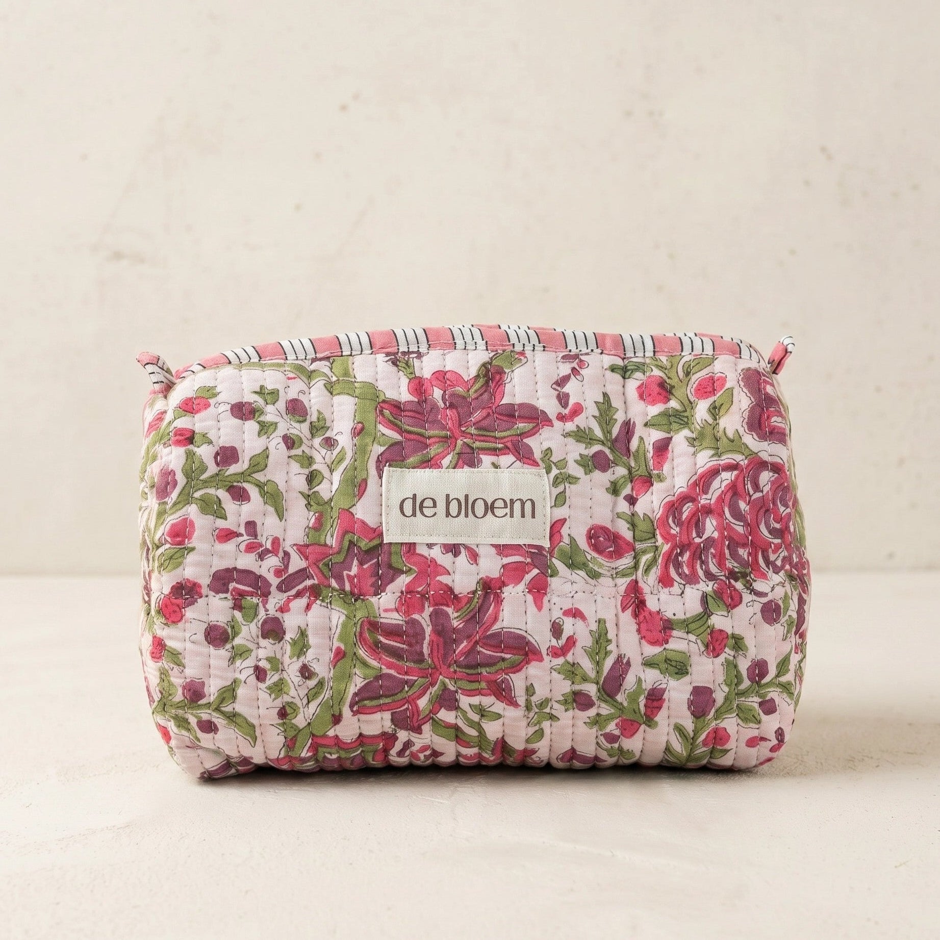 Floral-patterned pouch with 'de bloem' label on a light background