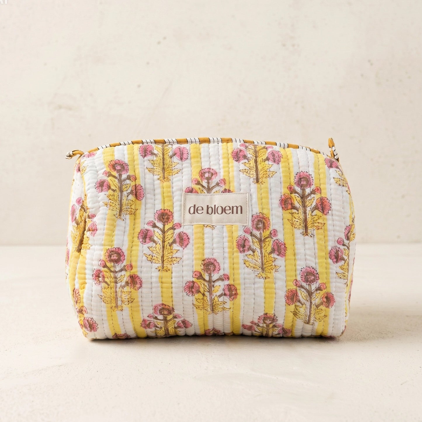 Floral patterned pouch with 'de bloem' branding on a beige background