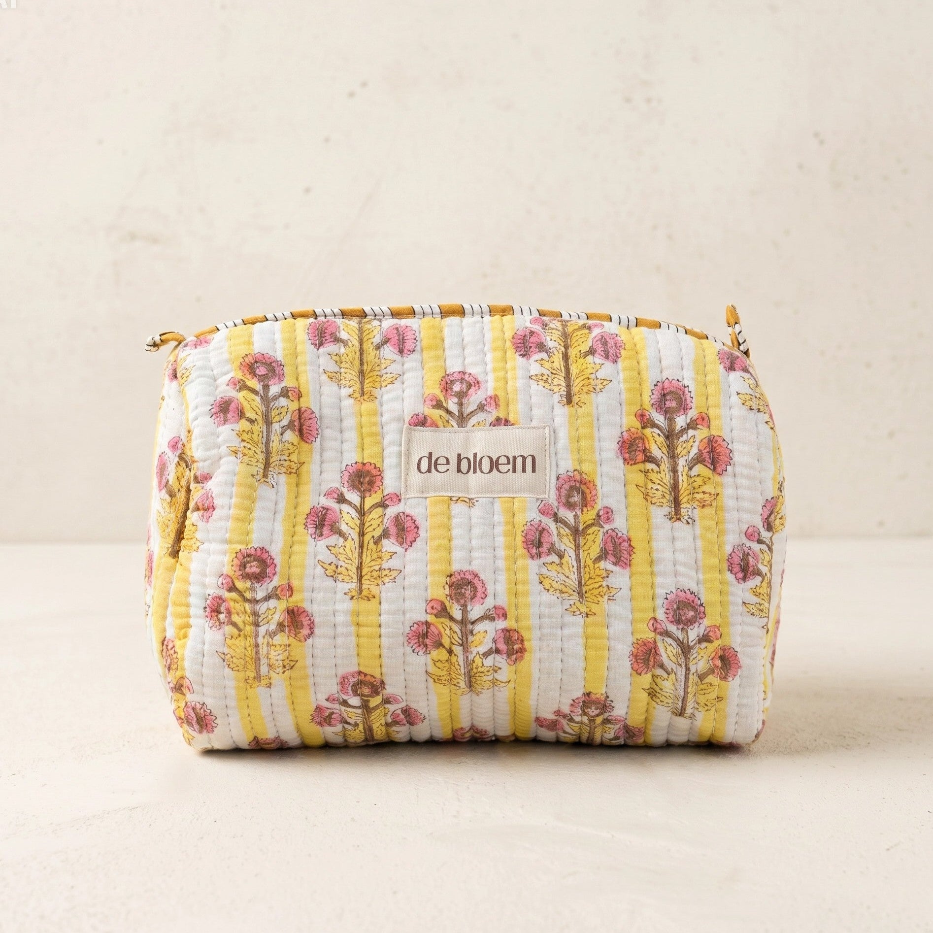 Floral patterned pouch with 'de bloem' branding on a beige background