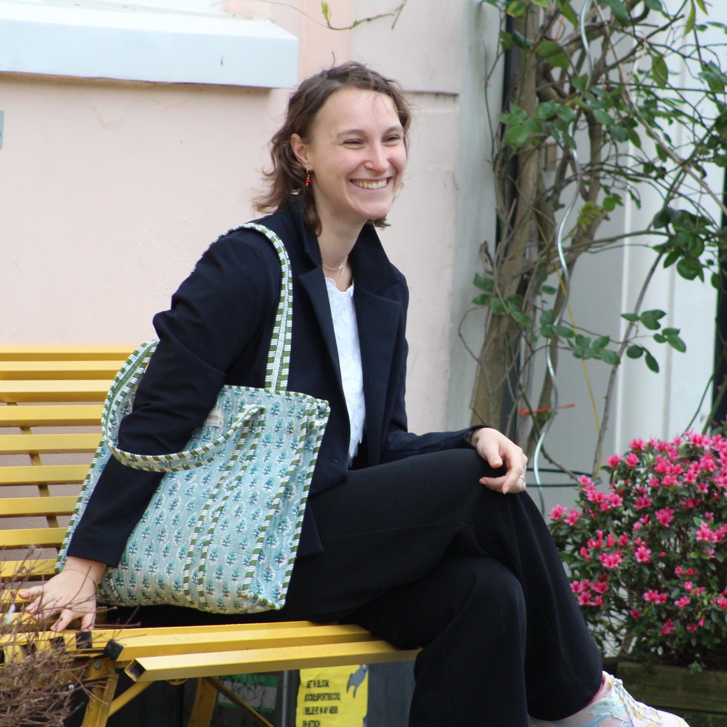 woman sitting on bnch withiris tote bag