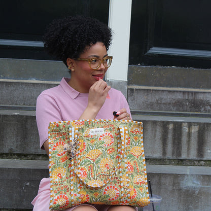 Person holding a floral-patterned bag on a concrete step