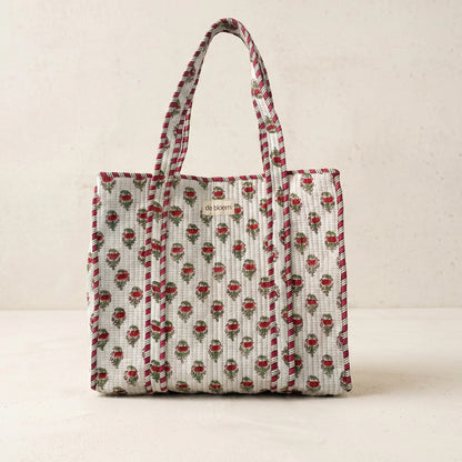Patterned tote bag with visible brand logo on a beige background