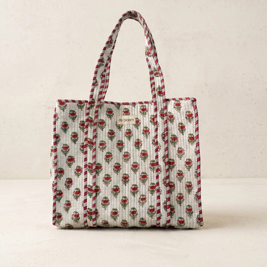 Patterned tote bag with visible brand logo on a beige background