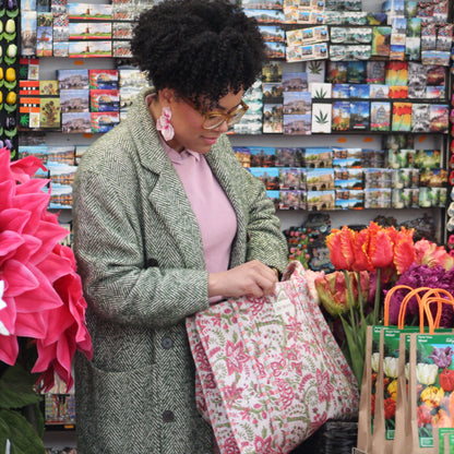 Woman shopping for flowers in a store with colorful displays.