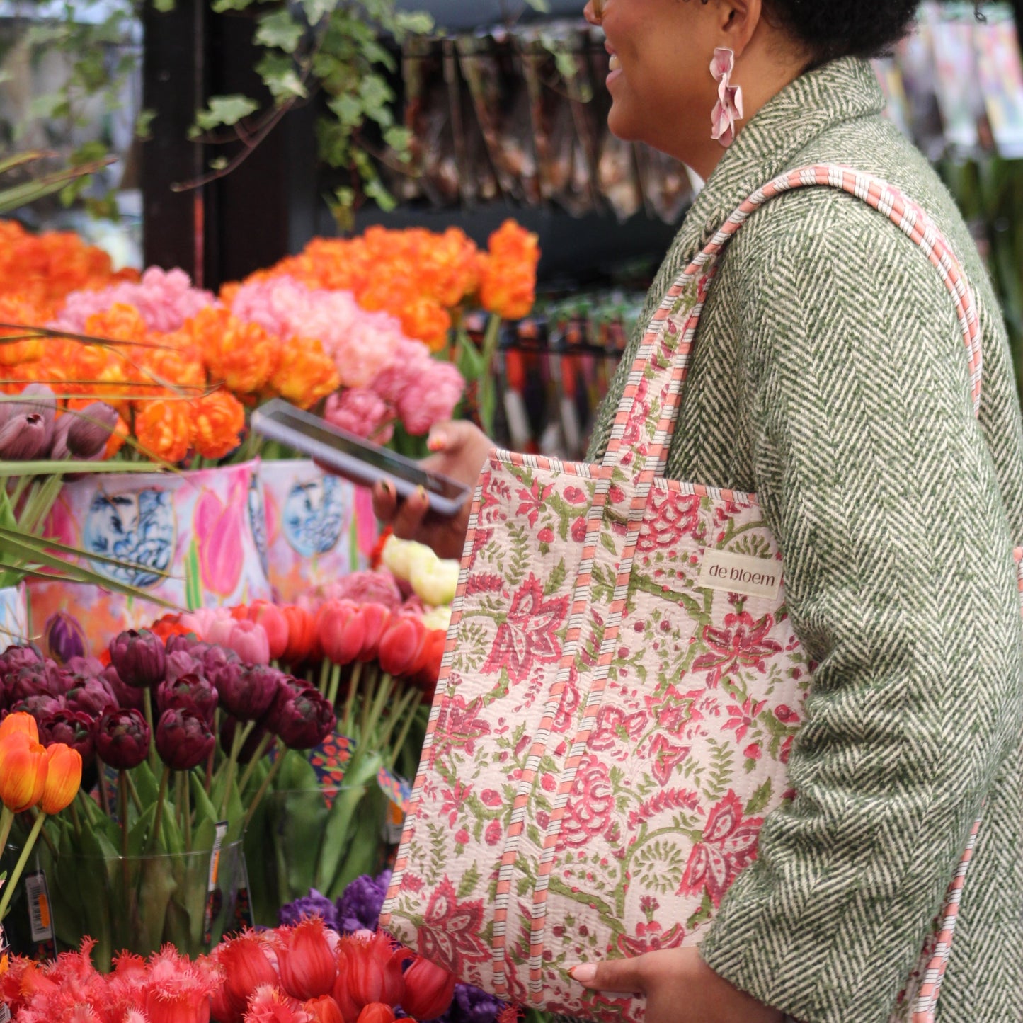 Woman sitting on a bench with flowers and plants around her